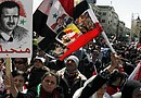 Varios sirios y palestinos ondean banderas y muestran fotos del presidente sirio Bachar al Asad mientras gritan eslóganes contra Israel, durante una manifestación convocada en la plaza Sabe Bahrat de Damasco, Siria