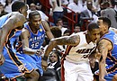 Mario Chalmers (2-d), jugador de los Heat, es marcado por Kendrick Perkins (i), Kevin Durant (2-i) y Thabo Sefolosha (d), de los Thunder, durante el cuarto partido de la final de la NBA, en el American Airlines Arena de Miami, Florida (EE.UU.)