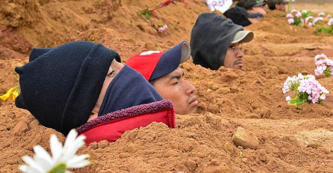 Reos bolivianos protestan enterrándose