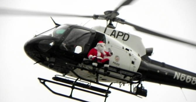 Santa Claus reparte en helicóptero regalos a niños