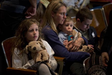 Una madre con sus hijos en la vigilia en donde habló el presidente Barack Obama el domingo 16 de diciembre.