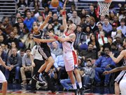 El argentino Manu Ginobili (izq.) de los San Antonio Spurs lanza el balón al aro ante la marca de Marcin Gortat de los Wizards en cotejo de la NBA realizado el martes 13 de enero de 2015 en el Verizon Center de Washington, DC.