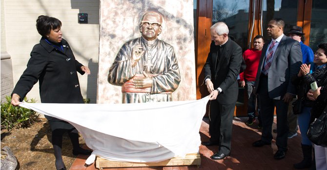 La alcaldesa de Washington, DC, Muriel Bowser desvela una imagen del arzobispo salvadoreño Monseñor Óscar Romero, el sábado 21 de marzo de 2015, durante a dedicatoria de un edificio de la Mount Pleasant, en DC, al arzobispo.