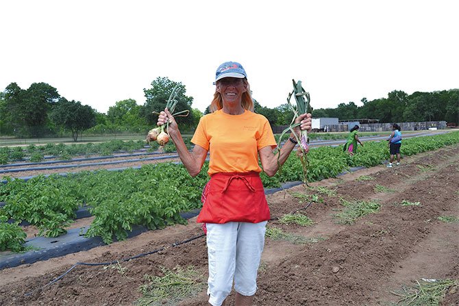 NATURAL. Lisa Baine mostrando la cosecha de cebollas.

