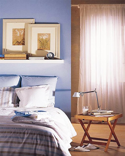 Con cuadrantes y una balda en la que apoyar cuadros se ahorra el cabecero; y no pare hasta encontrar una mesita a buen precio. No olvide algunos cuadros apropiados a la decoración.