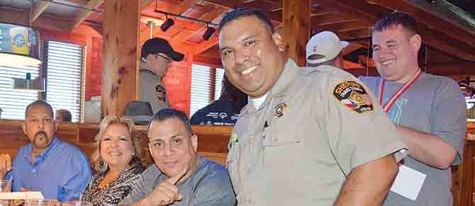 SERVICIO. El oficial Pete Guerra, alguacil de Travis County, en acción, asistiendo con gusto a una familia que llegó a comer a Texas Roadhouse.