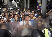 Los manifestantes anti-gubernamentales enfrentan a los oficiales de la guardia nacional durante una protesta contra la decisión de la Corte Suprema de tomar los poderes del Congreso liderado por la oposición en Caracas, Venezuela, el 31 de marzo de 2017.