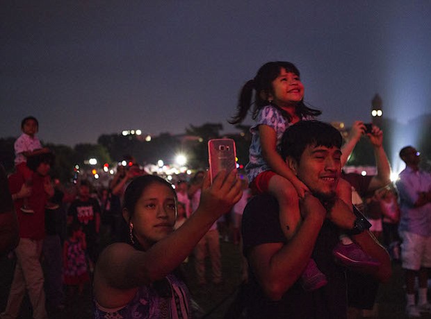 Izabel Yac disfruta los fuegos artificiales en los hombros de su padre en el Monumento de Washington en Washington, D.C.