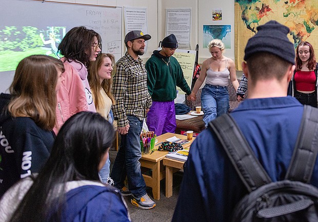 Estudiantes se toman las manos en círculo antes que termine el día escolar. Los estudiantes se reúnen a diario con consejeros y participan de programas de apoyo diseñados como Alcohólicos Anónimos.