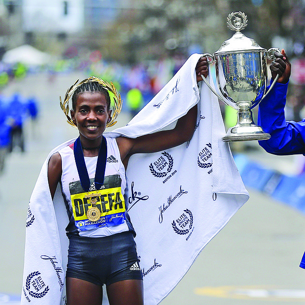 El keniano Lawrence Cherono (d) y la etíope Worknesh Degefa (i) posan para los fotógrafos tras proclamarse vencedores de la 123 edición del Maratón de Boston en la categoría masculina y femenina, respectivamente, este lunes en Boston.