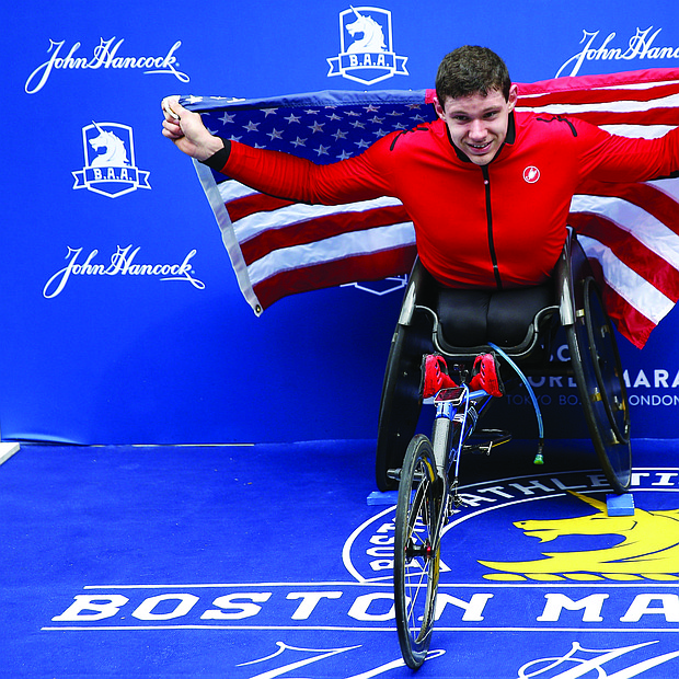 El estadounidense Daniel Romanchuk posa para los fotógrafos tras ganar en la competición masculina de silla de ruedas de la 123 edición del maratón de Boston.