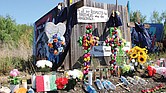 DESTINO. Flores, velas, cruces y letreros en el sitio del memorial donde más de 51 migrantes fueron encontrados muertos en San Antonio, Texas. Las temperaturas alcanzaron los 101 grados el día que los migrantes fueron encontrados dentro de un tractor -remolque.