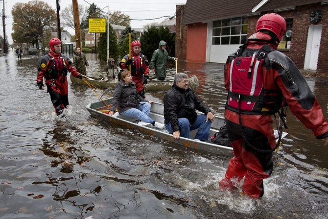 En la ciudad de Little Ferry, Nueva Jersey, rescatistas ayudan el 31 de octubre a los residentes. AP