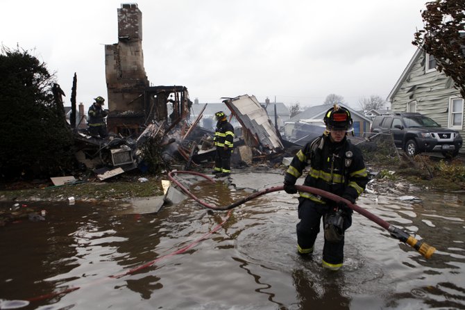 Un bombero lucha contra el agua en Linderhurst, Nueva York. AP
