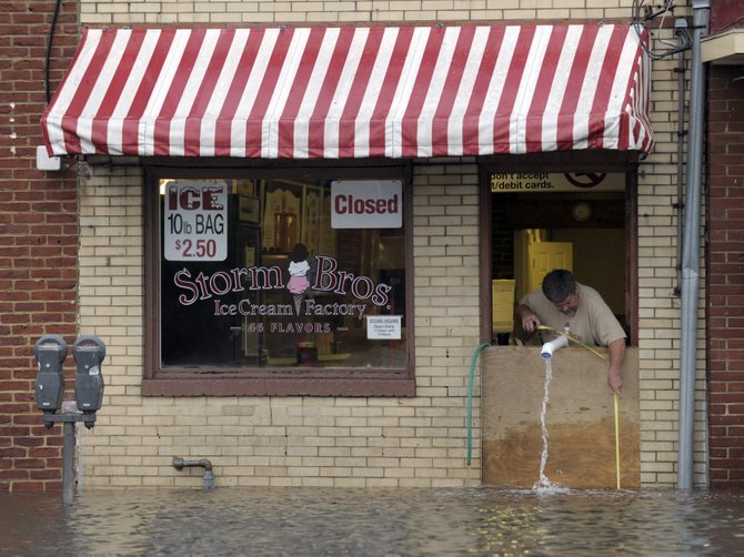Sveinn Storm, dueño de una heladería en Annapolis, Maryland, saca agua de su negocio tras el paso de Sandy. AP