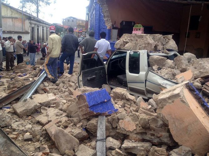 Un auto cubierto de escombros en una calle de San Marcos, Guatemala.