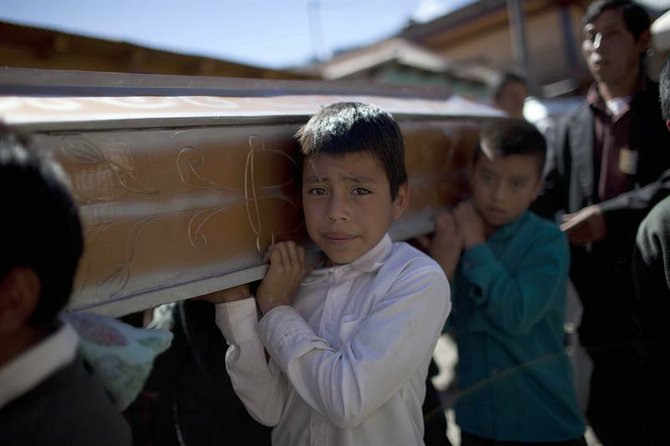 Varios niños cargan un ataúd el viernes 9 de noviembre, durante el funeral de 10 miembros de una misma familia, víctimas del sismo.