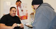 EXAMEN. Ignacio Aguirre muestra un kit de prueba a un cliente en NOVA Salud, el martes 27. Atrás Hugo Delgado.