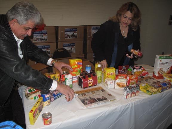 Ramón Pagan, de EMD SALES, y su esposa Mireya, organizan los alimentos en la entrega de Bolsas de Amor, el sábado 26.