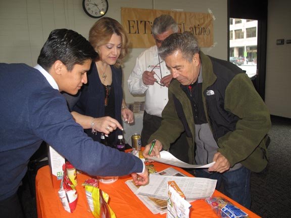 Gilberto Aguilar (der.) firma el comprobante de que recibió la suculenta caja de alimentos.