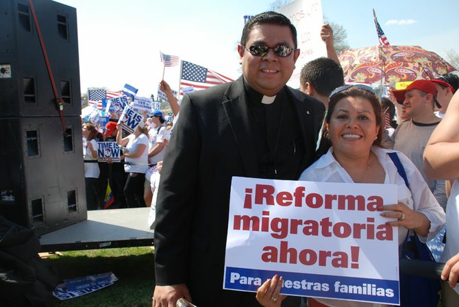 El padre Alex Díaz, vicario de la parroquia la Sagrada Familia en Dale City, Virginia, junto a Dora Escobar, dueña de las tiendas de envío de dinero La Chiquita Express en la marcha del 10 de abril frente al Capitolio.