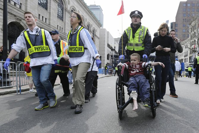 Socorristas ayudan a un niño y a su madre que resultaron con heridas menores tras las explosiones en la Maratón de Boston.