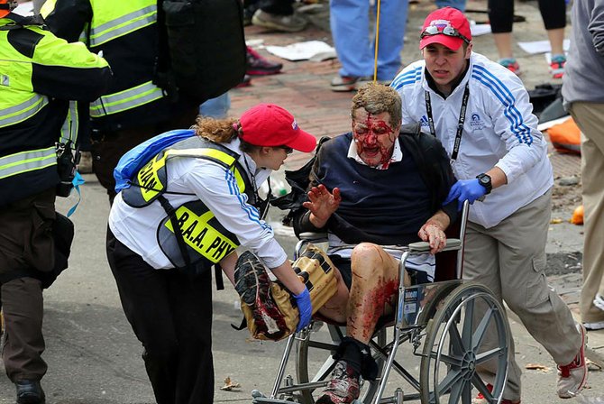 Rescatistas ayudan a un hombre que sangraba tras las heridas que sufrió por las explosiones de las bombas en Boston.