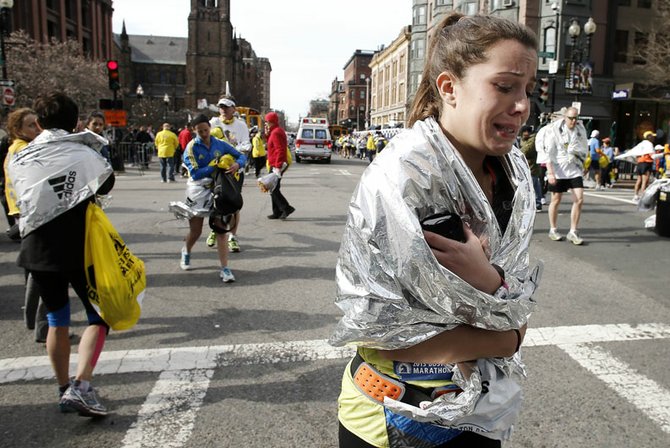 Una maratonista llora al ver la tragedia que dejó a tres muertos y más de 140 heridos en la Maratón de Boston al estallar dos bombas.