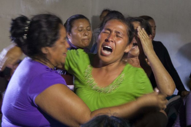 Familiares lloran la muerte de Darling Adriel Valle, el miércoles 28 de agosto de 2013, en la aldea el Suyatal al este de Honduras. Darling Valle fue uno de los seis hondureños fallecidos el domingo 25 de agosto de 2013 en el descarrilamiento del tren llamado "La Bestia", en México. Los inmigrantes iban trepados en los vagones en un intento por llegar a Estados Unidos.