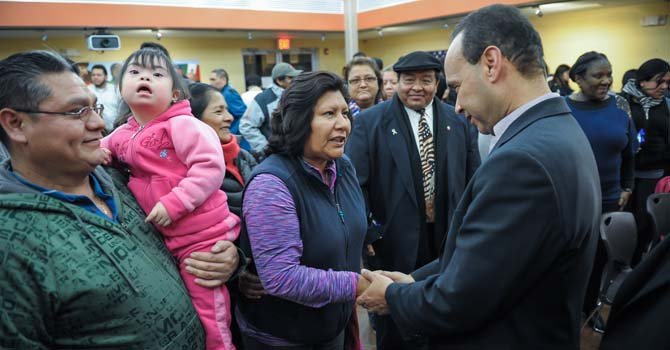 Amalia Zurita (centro), argentina, saluda al congresista Gutiérrez (der.), agradeciéndole por su dedicación a la comunidad. Carlos Crespo, mexicano, observa con su hija.
