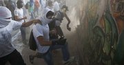 Manifestantes destruyen un muro para tener más piedras que arrojar hacia la Guardia Nacional Bolivariana durante una protesta contra el gobierno venezolano en Caracas, el martes 4 de marzo del 2014. A un año de la muerte de Hugo Chávez, Venezuela ha sido sacudida por semanas de manifestaciones que han dejado casi una veintena de muertos. (AP Foto/Rodrigo Abd)