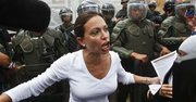 En esta fotografía de archivo del 16 de marzo de 2014 la diputada opositora venezolana María Corina Machado habla con periodistas ante una línea de agentes de la Guardia Nacional en Caracas, Venezuela. El líder de la Asamblea Nacional Diosdado Cabello informó el lunes 24 de marzo de 2014 que Machado, quien la semana pasada buscó intervenir en la Organización de los Estados Americanos para denunciar al gobierno venezolano, perdió su inmunidad parlamentaria tras violar la constitución al aceptar la silla ofrecida por Panamá para participar en ese foro regional.(AP foto/Esteban Felix, Archivo)
