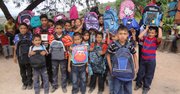 Los niños de la aldea Tamayupo en Honduras celebran recibir sus mochilas con útiles escolares el 5 de enero de 2014 gracias a la Glo Foundation, una iniciativa de la joven hondureña, Gloria Sierra, quien vive en Maryand.