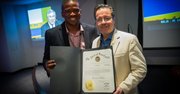 Jonathan J. Green (izq.) hace entrega al editor de El Tiempo Latino, Alberto Avendaño, de un reconocimiento oficial del Gobernador de Maryland, Martin O'Malley, a 23 años de servicio comunitario de la publicación, durante el evento del Mundial de Fútbol Brasil 2014 en el auditorio del Washington Post, el 9 de julio.