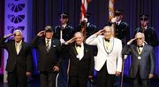 Miembros del 65to regimiento de Infantería del Ejército de Estados Unidos, saludan durante la interpretación del himno nacional estadounidense, tras recibir sus premios, durante los Premios de Herencia Hispana, en el Warner Theater, en Washington, el jueves, 18 de septiembre del 2014. (Foto AP/Alex Brandon)