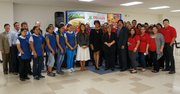 La alcaldesa de Baltimore, Rawlings-Blake (centro) junto a El Devarie, CEO de EMD Sales, y parte de los empleados de la compañía de distribución de productos alimenticios, el 23 de septiembre de 2014, en Baltimore, Maryland.