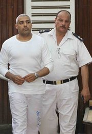 El Jefe del Buró en el Cairo de la cadena “Al Jazeera English”, Mohamed Fadel Fahmy, es escoltado por un guardia durante una audiencia de su juicio en Egipto