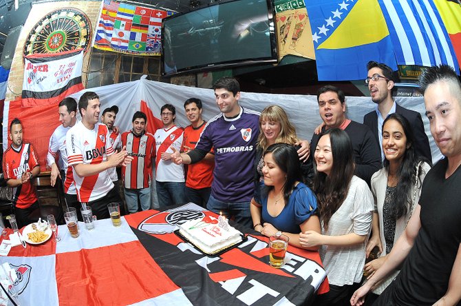 Francisco Morán (camisa morada) celebra su cumpleaños 28 con los miembros de la Filial de River Plate en el restaurante The Lucky Bar en Washington, DC, el jueves 12 de marzo de 2015.