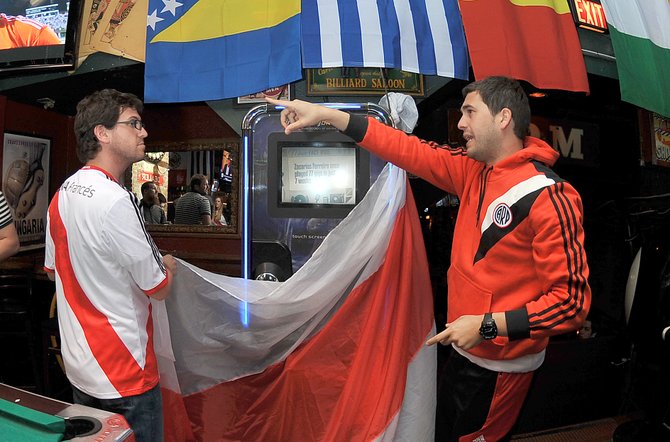 Javier Bilon y Patricio Violini durante la instalación de las banderas en el restaurante The Lucky Bar el jueves 12 de marzo de 2015.