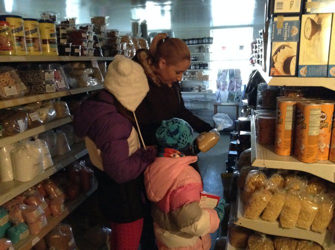 Jóvenes turistas escogen alimentos en una tienda de productos amish.