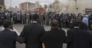 Una barrera de la policía bloquea una calle de Baltimore a manifestantes durante protestas por la muerte de Freddie Gray hoy, lunes 27 de abril de 2015