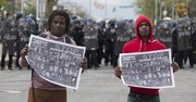 Jóvenes sostienen carteles que dicen "Detengan el asesinato por policías" durante protestas después del funeral Freddie Gray hoy, lunes 27 de abril de 2015, en Baltimore