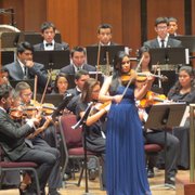 Una joven interpreta un solo de violín durante el concierto de la Orquesta Don Bosco en el Kennedy Center.