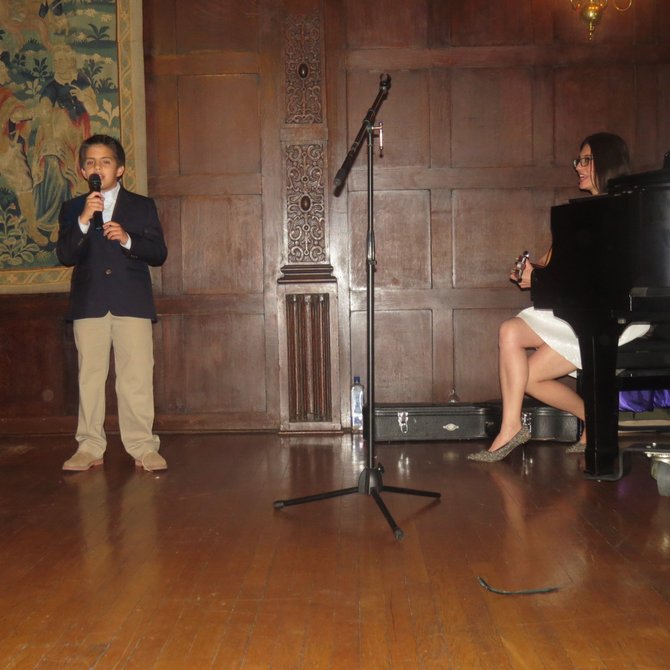 Un niño que toma clases de canto  interpreta la melodía América de Nino Bravo junto a Narda Muñoz.