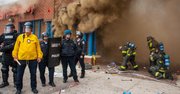 DESTRUCCIÓN. Policías y bomberos frente a la tienda CVS, incendiada en los disturbios del 27 de abril.