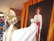 OBRA. El nuncio apostólico León Kalenga bendice una pintura de Romero en la casa de la familia Gutiérrez en Ciudad Barrios.
