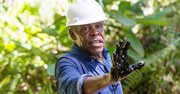 El actor estadounidense Danny Glover muestra su mano con residuos de crudo de una vieja piscina de la ex Texaco, el 5 de noviembre de 2013, en la zona Aguarico 4, la provincia de Sucumbios (Ecuador), en la amazonía ecuatoriana donde operó la empresa estadounidense Chevron, condenada por la justicia local a un pago millonario por contaminación ambiental.