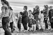 ESPERA. Mujeres y niños hacen cola para poder recibir una comida en Idomeni, Grecia.