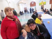 ABRAZO. La directora de OLA, abraza a una de las personas que llega habitualmente a cenar a la iglesia Sagrado Corazón. Al lado, Silvia Rodwan, de la Alianza Latina USA. 