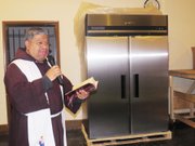 El padre Moisés Villalta bendice el refrigerador donado por Alianza Latina USA a la iglesia Sagrado Corazon, el 7 de abril de 2016. (Milagros Meléndez-Vela/ETL)